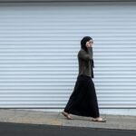 woman walking beside closed roll-up door