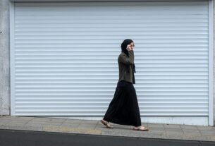 woman walking beside closed roll-up door