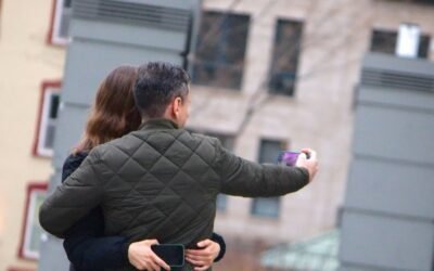 a man and a woman taking a picture with a cell phone