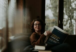 woman in brown coat using black laptop computer
