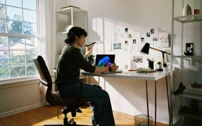 Person working at desk with laptop and phone.