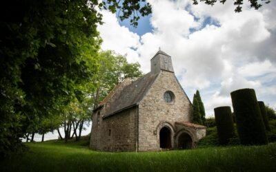 A quaint stone church sits peacefully under clouds.