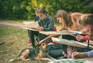 Children drawing outdoors with a dog nearby