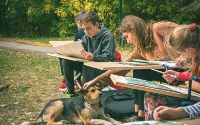 Children drawing outdoors with a dog nearby