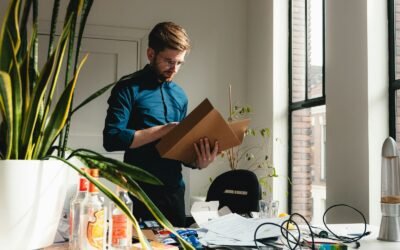 a man standing in an office holding a box
