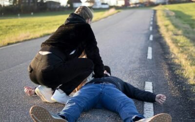 a man kneeling on the side of a road with another man kneeling on the ground