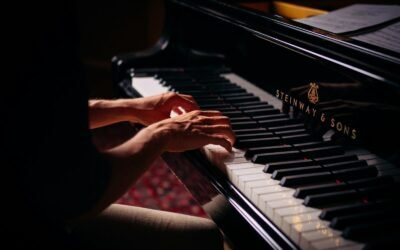 person playing black upright piano