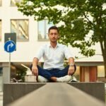 man in white dress shirt sitting on gray concrete bench during daytime