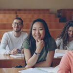 Students smiling in a lecture hall classroom